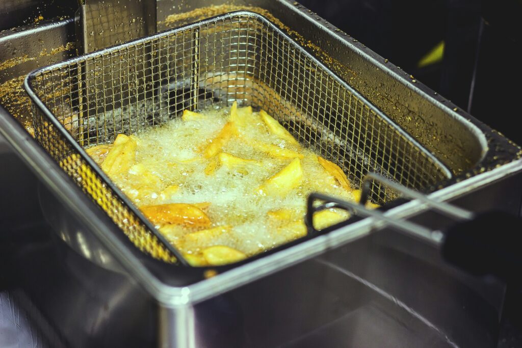 Pommes frites i en friturekurv med boblende olie