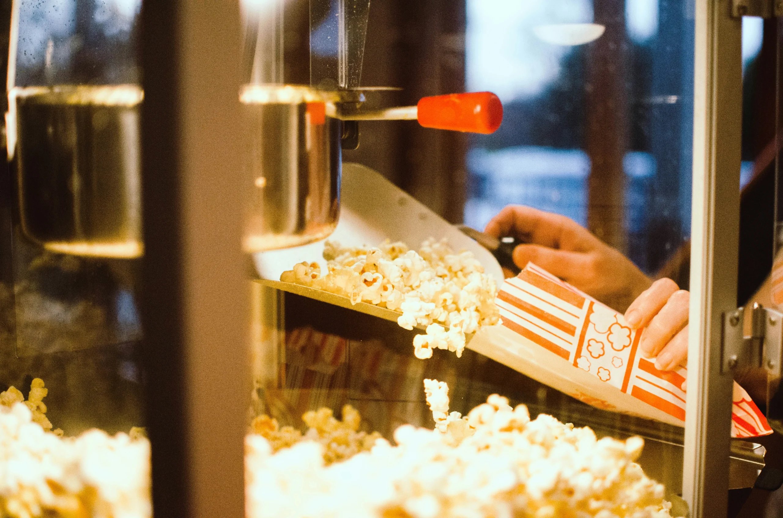 Popcorn fyldes i en papirpose fra en popcornmaskine